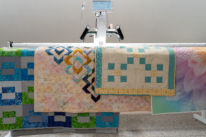 Longarm Quilting Machine with multiple Quilts on top of it